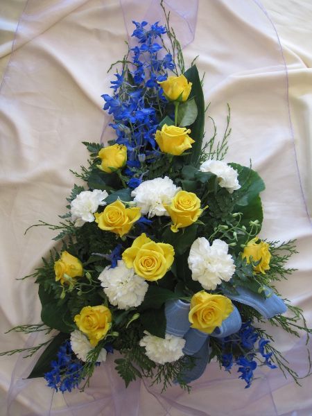 Hautavihko valkoisilla, keltaisilla ja sinisillä kukilla