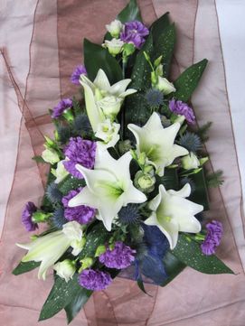 Hautavihko valkoisilla ja violeteilla kukilla
