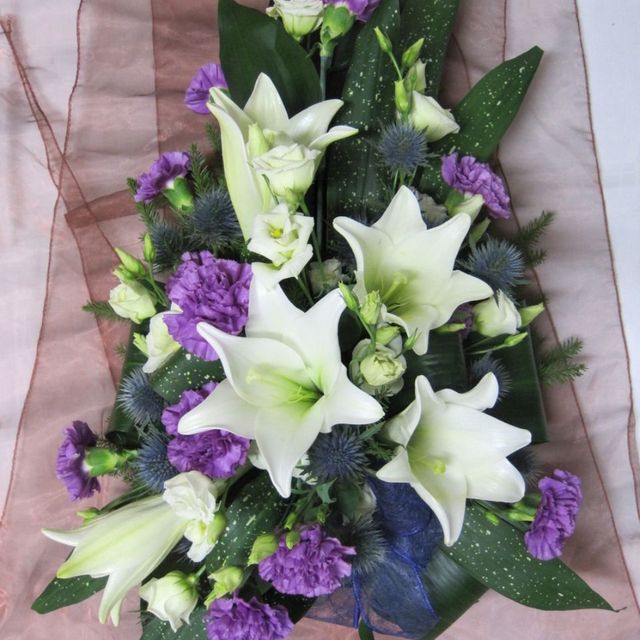 Hautavihko valkoisilla ja violeteilla kukilla