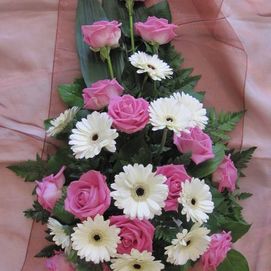 Valkoisist aja vaaleanpunaisita kukista sidottu hautavihko
